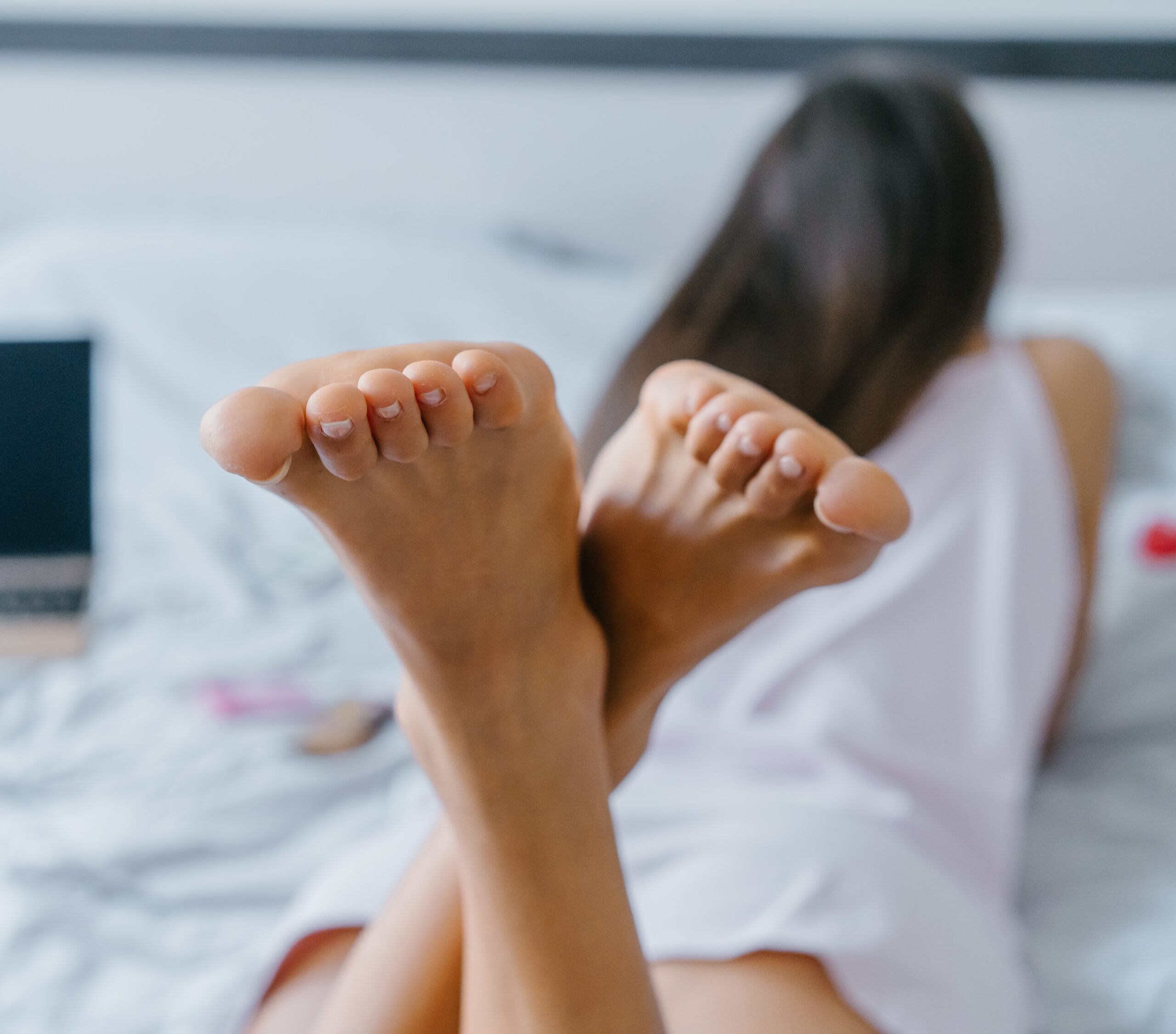 Экзотичная женщина раздвигает ножки лежа в кровати и гладит пальцами вагину 